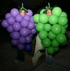 two women holding balloons in the shape of grapes