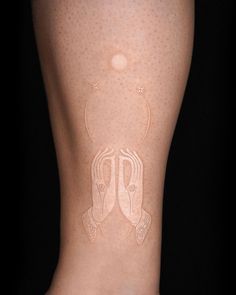 a woman's legs with white tattoos on them