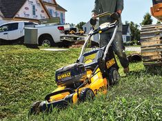 a man mowing the grass with a lawnmower