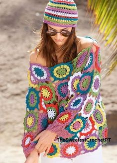 a woman wearing a colorful crochet sweater and hat