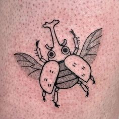 a close up of a person's leg with a bug tattoo on it