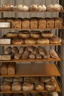 breads and loaves on shelves in a bakery