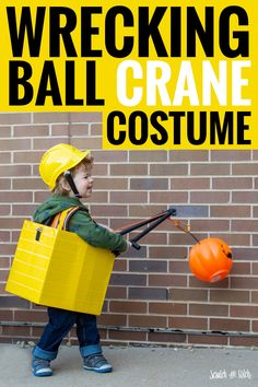 a young boy wearing a construction costume and carrying a yellow box with an orange ball in it