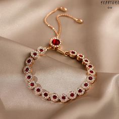 ✓ Ruby Red Bracelet   ✓ Gala Accessory✓ Luxurious Jewelry   Step into a luxurious world and indulge yourself with a sophisticated bracelet. Made from gold plated base, decorated with large vibrant red gems and dazzling white stones. The bracelet is adjustable, just simply pull the cord until it fits as desired. Luxury, elegance and breath taking sparkle all built in this piece of jewelry. Built from thick circles, each decorated with a large ruby red gem and bedazzled all around with tiny white stones. The gold and red color combination will always suggest glamour and luxury, with a festive flair. This piece of jewelry makes a great match with elegant, evening wear, for events, parties and gala celebrations. Buy it for yourself or gift it, makes a sentimental gift for a birthday, Christmas