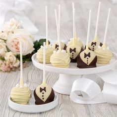 chocolate covered cake pops with white frosting and bow ties on them sitting on a plate