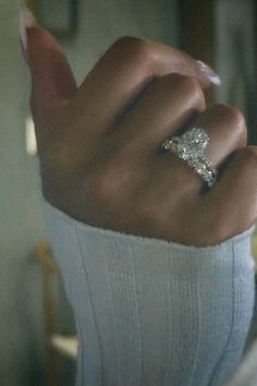 a woman's hand with a diamond ring on it