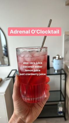 a person holding up a glass with ice and water in it that says adrenal o'clocktail