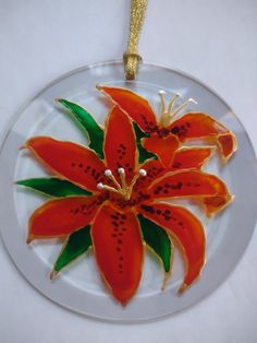 a glass ornament with red flowers on it