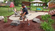 a man is shoveling dirt in his backyard