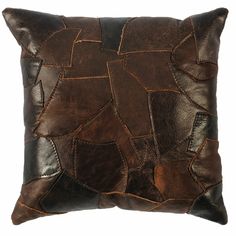 a brown and black leather pillow on a white background with an abstract design in the middle