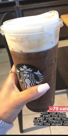 a woman's hand holding up a cup of coffee