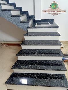 the stairs are made out of marble and have black granite treading on each side