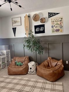 two bean bags sitting on the floor in front of a wall with surfboards and other items