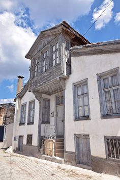 an old wooden house with windows and shutters