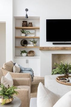 a living room filled with furniture and a flat screen tv mounted on the wall above a fireplace