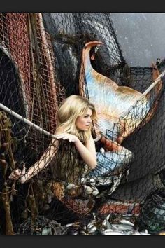 a woman leaning against a fence with her hands on her hips