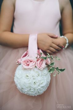 a woman in a pink dress holding a white and pink flower arrangement