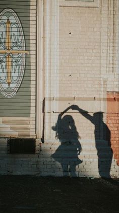 the shadow of a person standing in front of a building with a cross on it