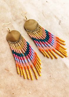 a pair of colorful beaded earrings on top of a table