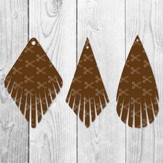 three brown and white earrings on wooden background