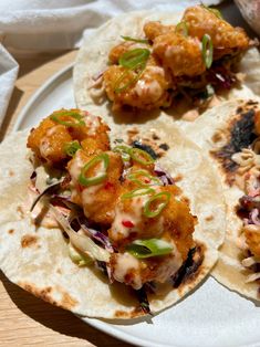 three tacos on a white plate topped with meat and veggie toppings