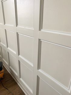 a man is using a power drill to paint the walls in his home with wood flooring