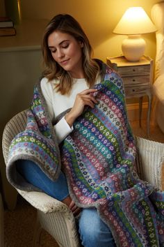 a woman sitting in a chair holding a blanket