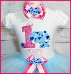 "Super cute Blues Clues personalized birthday tutu outfit. You can purchase the shirt alone or the whole outfit , use the drop down menu to add the items you are wanting to purchase. The shirt is a boutique style white cotton tee shirt with a pink glittery appliqued number with Blue dog and a embroidered name. The full a fluffy ribbon trim tutu was made with a light blue tulle and finished with a hot pink ribbon and has a removable bow you can also included the matching bow to complete the outfi Fun Blue Top For First Birthday, Fitted Blue Top For Birthday, Blue Fitted Top For Birthday, Hot Pink Ribbon, 2nd Birthday Party For Girl, Ribbon Trim Tutu, Birthday Tutu Outfit, Embroidered Name, Blues Clues