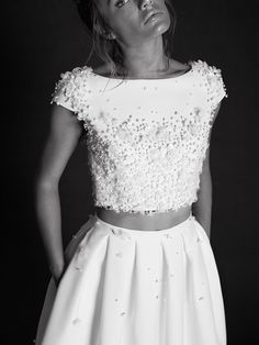 a black and white photo of a woman wearing a dress with flowers on the top