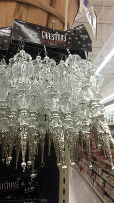 many clear glass chandeliers hanging from the ceiling in a store or showroom