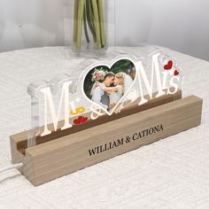 a personalized acrylic photo on a wooden stand with flowers in the background