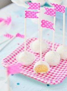 marshmallows on a pink and white checkered tablecloth are being held by toothpicks