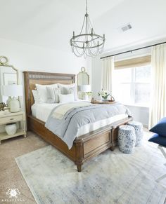 a bedroom with a large bed and a chandelier hanging from it's ceiling