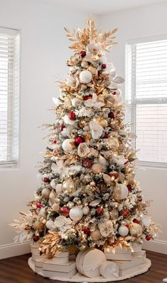 a decorated christmas tree in an empty room with white and gold ornaments on the top