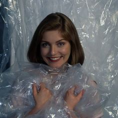 a woman is wrapped in plastic and posing for the camera with her hands on her hips