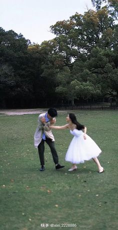 a man and woman are playing with a frisbee in the grass outside on a sunny day