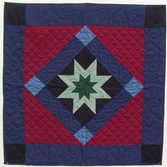 a blue and red quilt with a green star on it