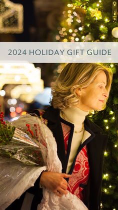 a woman holding flowers in front of a christmas tree with the words, holiday gift guide