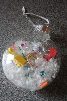 a glass ornament filled with ice and plastic toys