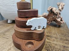 a wooden bear figurine sitting on top of a stack of wood blocks