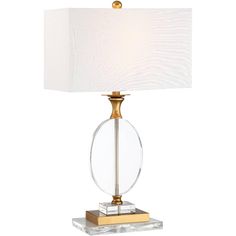 a clear glass table lamp with a gold base and white linen shade on the top