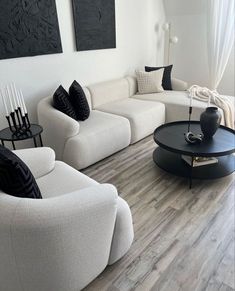 a living room filled with white furniture and black accents