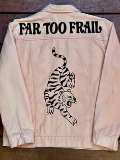 a white jacket with a tiger on it that says, far too fraill