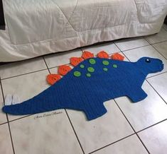 a blue crocheted dinosaur rug on the floor