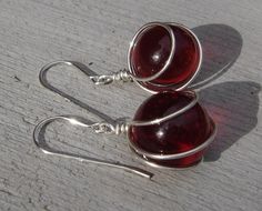 "We cleverly and securely wire wrapped these 1/2\"(1.3cm) ruby red glass marbles in sterling silver to handmade these fun dangle earrings. The entire earring measures 1 1/2\" (3.9cm) from the top of the sterling silver earwire to the bottom of the earring. These are the perfect match to our Ruby Red Glass Marble pendant which can be found in the Glass Earrings/Pendant section of our shop.You can see all the other colored glass marble jewelry we have in that section too: http://www.etsy.com/shop/ Red Sterling Silver Wire Wrapped Earrings, Gift Wire Wrapped Silver-plated Earrings, Wire Wrapped Round Earrings For Gift, Gift Wire Wrapped Round Earrings, Wire Wrapped Round Earrings, Wired Jewelry, Marble Jewelry, Marble Earrings, Earring Wire