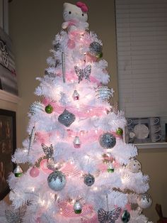 a white christmas tree with pink and silver ornaments