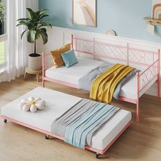 two twin beds with mattresses on them in a room next to a potted plant