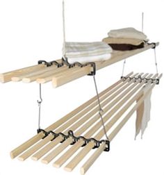 a wooden bench that has some clothes hanging from it's hooks on the hangers