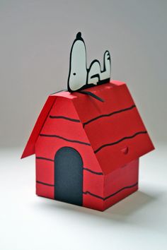 an origami house with a dog on top and a bird perched on the roof