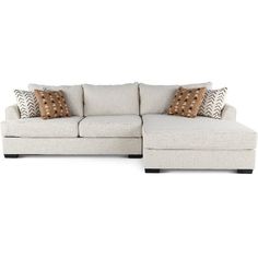 a white sectional couch with pillows on it's back and the seat facing outward